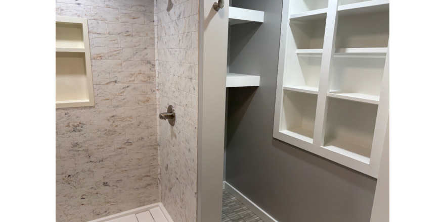 a walk in shower sitting next to a white toilet