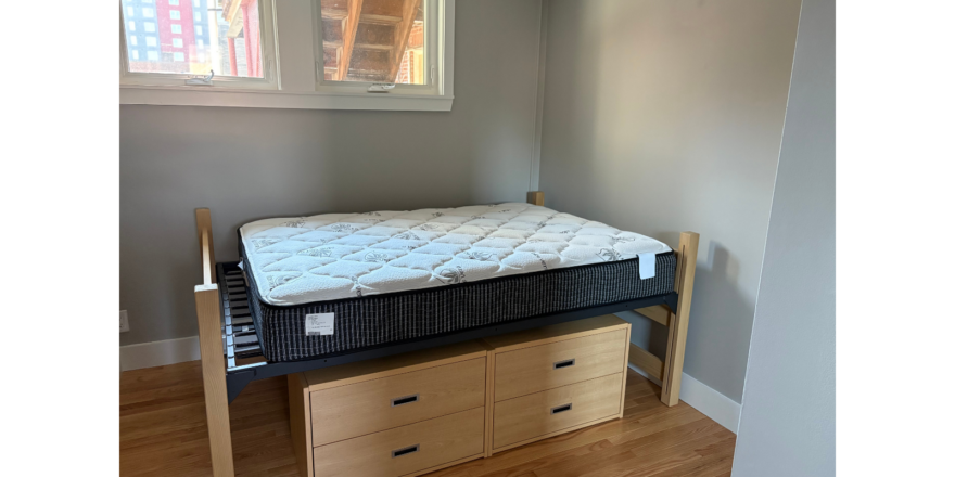 a bed sitting on top of a wooden dresser