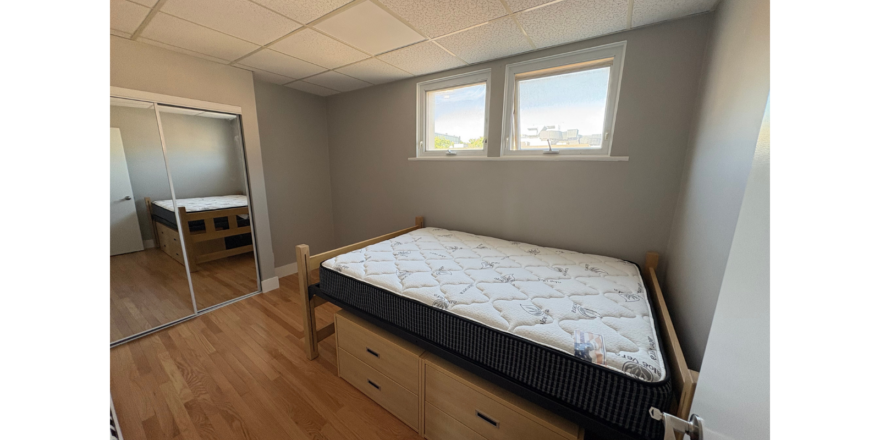 a bedroom with a bed, dresser and mirror