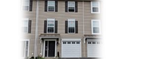 Exterior of townhouse with tan siding and dark brown shutters and front door