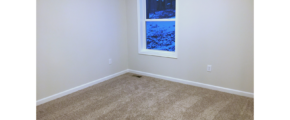 Unfurnished bedroom with tan carpet.