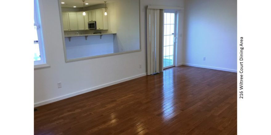 Dining area with hardwood floors, large mirror, and sliding glass door