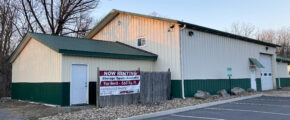 white and dark green building with garages