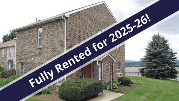 a house for sale with a blue ribbon in front of it
