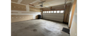 an empty room with a garage door and a window