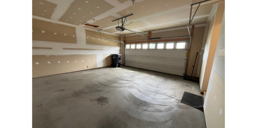 an empty room with a garage door and a window