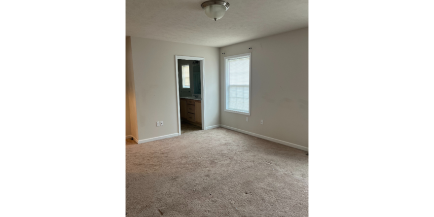 an empty room with a door and a window