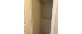 a closet with a door open to a bathroom