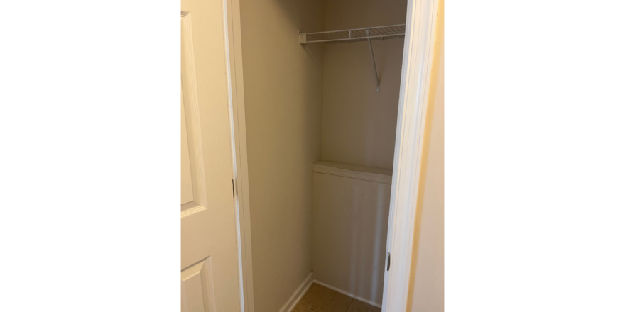 a closet with a door open to a bathroom
