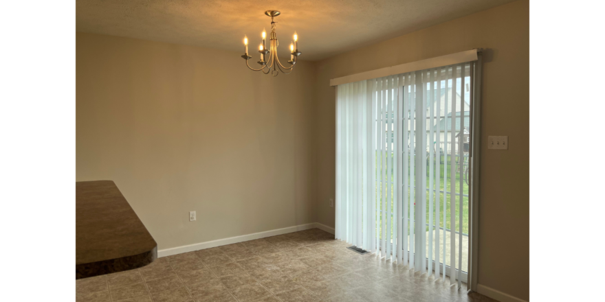 a living room with a chandelier and sliding glass doors