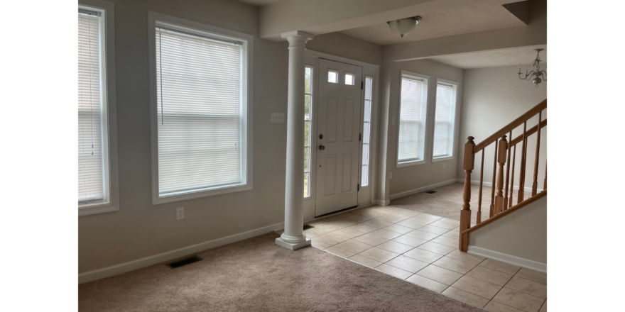 an empty room with three windows and a door