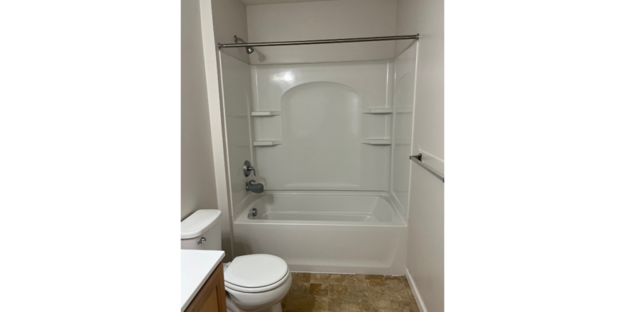 a bathroom with a toilet, shower, and sink