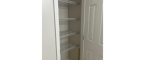 a walk in closet with shelves and a door