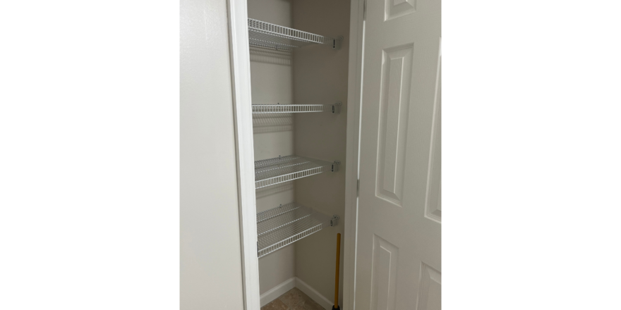 a walk in closet with shelves and a door