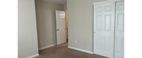 an empty room with a door and a closet