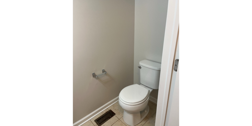 a white toilet sitting in a bathroom next to a shower