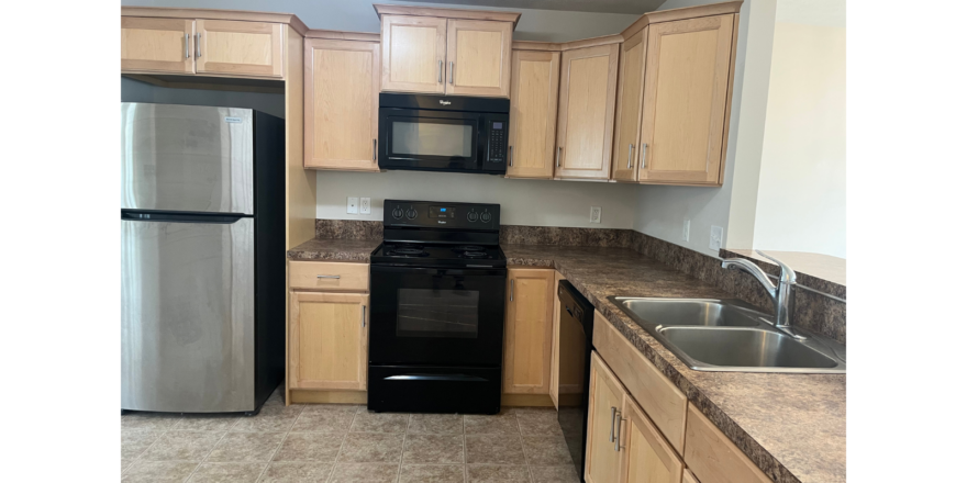 a kitchen with a sink, refrigerator, and microwave