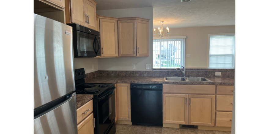 a kitchen with black appliances and wooden cabinets