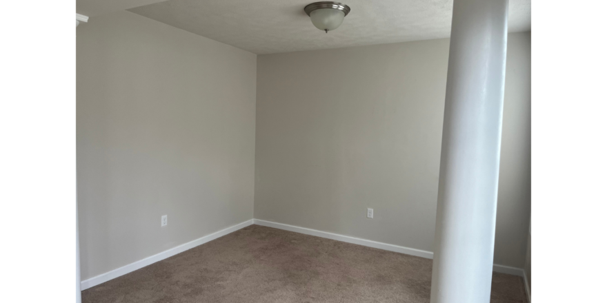 an empty room with a ceiling fan in it