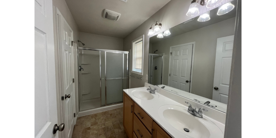 a bathroom with two sinks and a shower