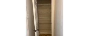 an empty closet in a house with a door open