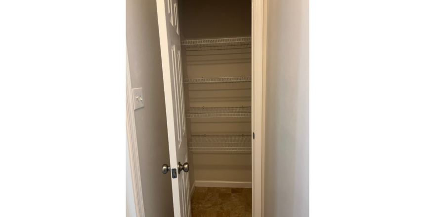 an empty closet in a house with a door open
