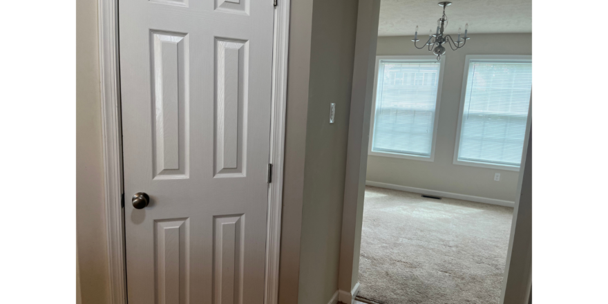 a white door in a room with a chandelier