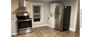 Kitchen with window, washer dryer, stainless steel stove and fridge. LVP flooring.