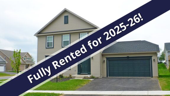 a house for sale with a blue ribbon in front of it