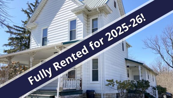 a white house with a blue ribbon in front of it