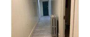 a long hallway with a radiator in the middle of it