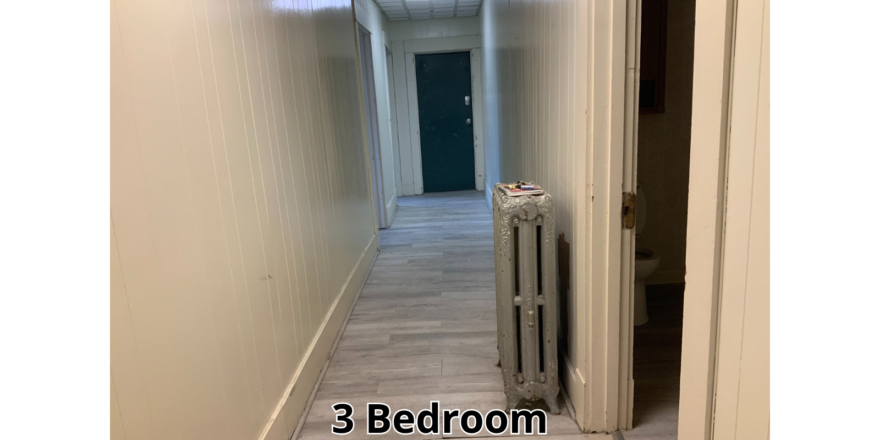 a long hallway with a radiator in the middle of it