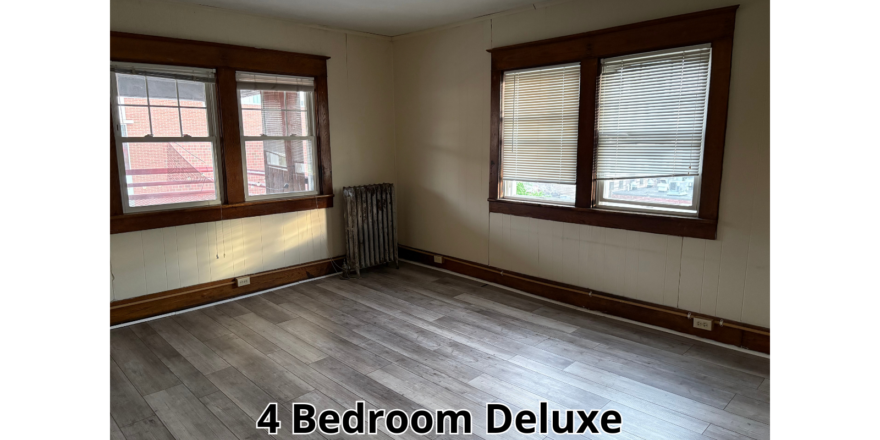 an empty room with wood floors and windows