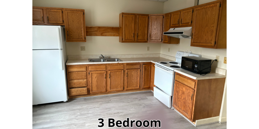 a kitchen with white appliances and wooden cabinets