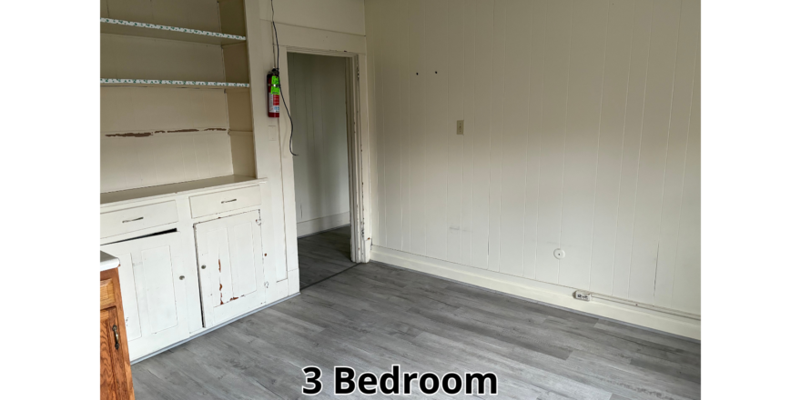 an empty room with white cabinets and a door