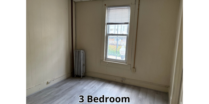 an empty room with a radiator and a window