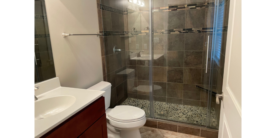 a bathroom with a walk in shower next to a sink