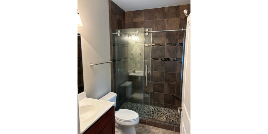 a bathroom with a walk in shower next to a sink