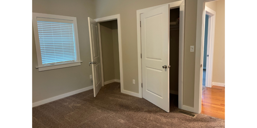an empty room with two doors and a window