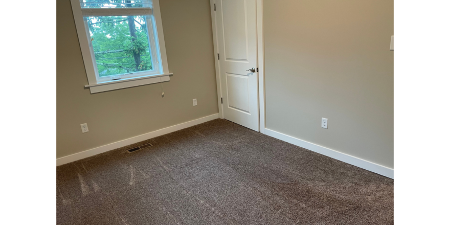 an empty room with a window and a door