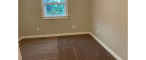 a empty room with a window and carpet