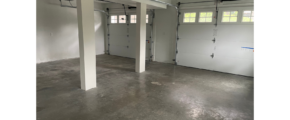 an empty garage with two garage doors open