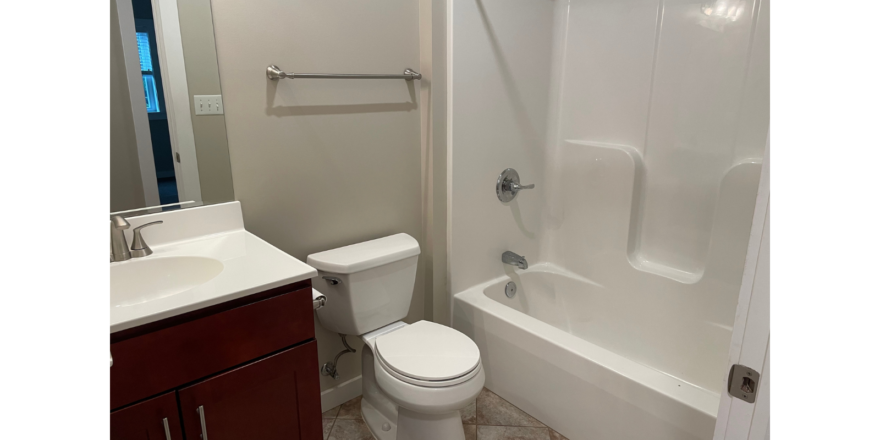 a white toilet sitting next to a bath tub