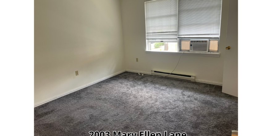 an empty room with a window and a radiator