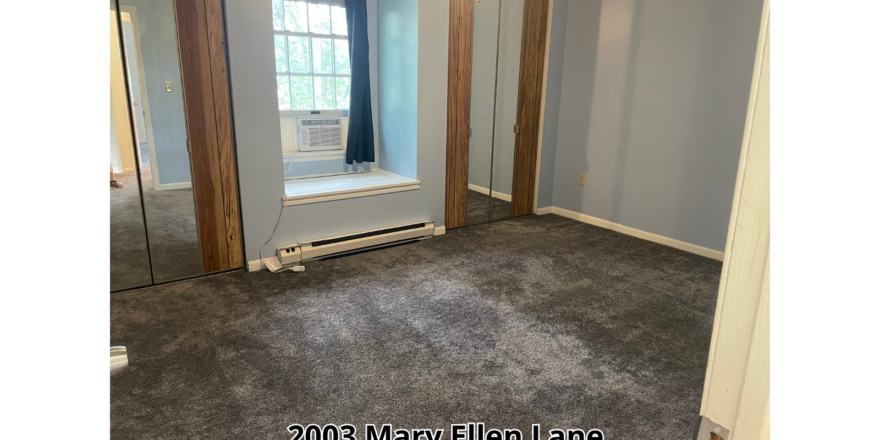 an empty room with a large mirror and a window