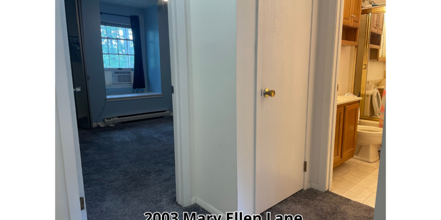 a hallway leading to a bathroom with a toilet