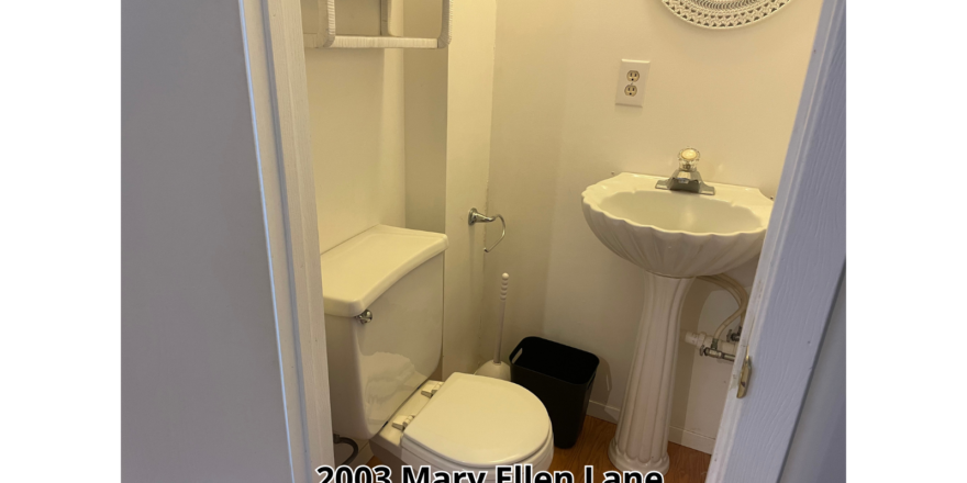 a bathroom with a toilet, sink and mirror