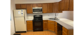 a kitchen with a refrigerator, stove, microwave and cabinets