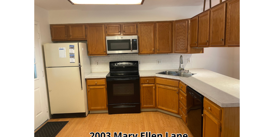 a kitchen with a refrigerator, stove, microwave and cabinets
