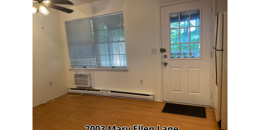 an empty room with a fan and a door